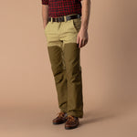 A person wearing a red plaid shirt, a brown belt, leather shoes, and Duck Head Field Canvas Briar Pant in two-tone khaki and olive green.