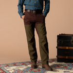 A person wearing brown Duck Head Field Canvas Briar Pant with olive green leg panels and suede boots.