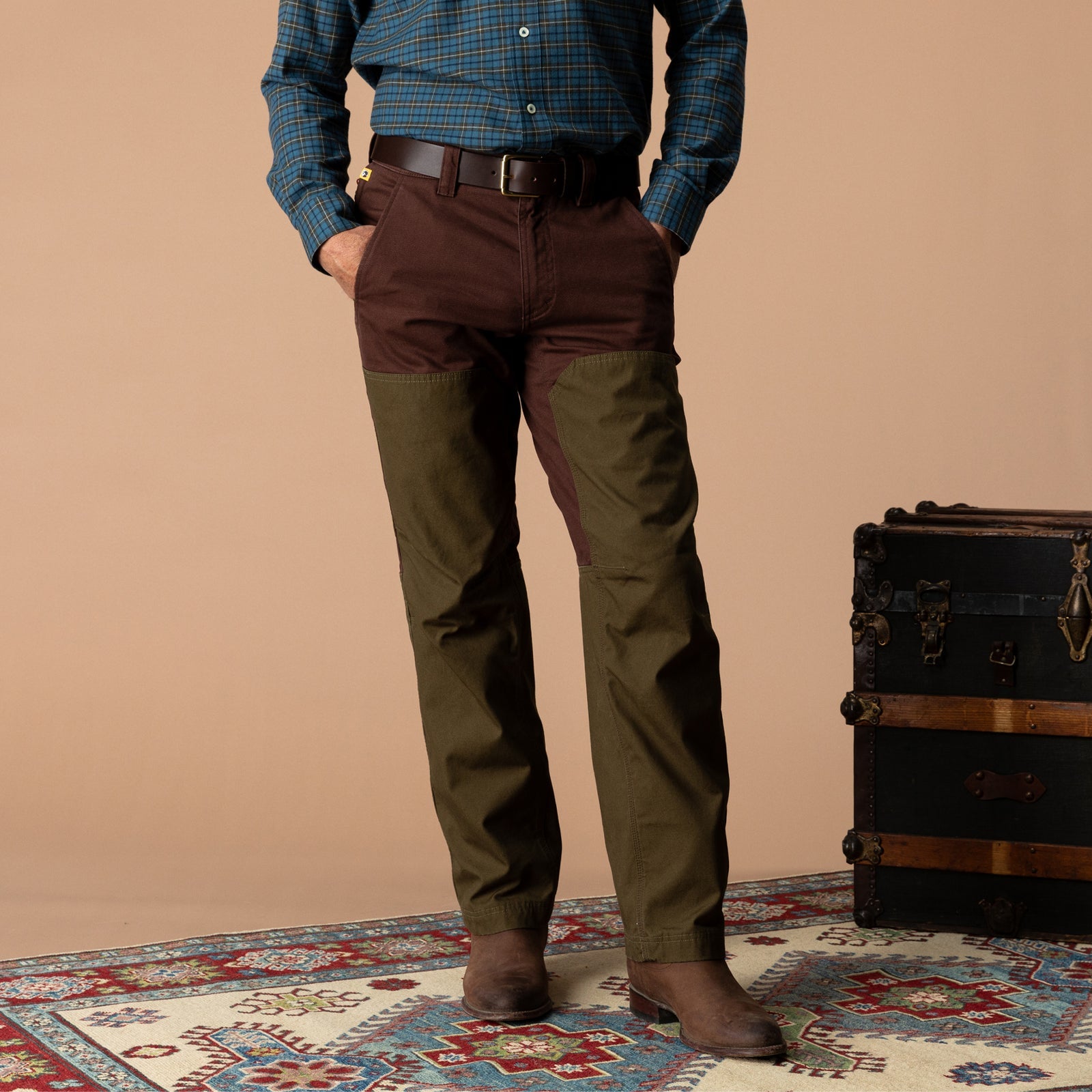 A person wearing brown Duck Head Field Canvas Briar Pant with olive green leg panels and suede boots.