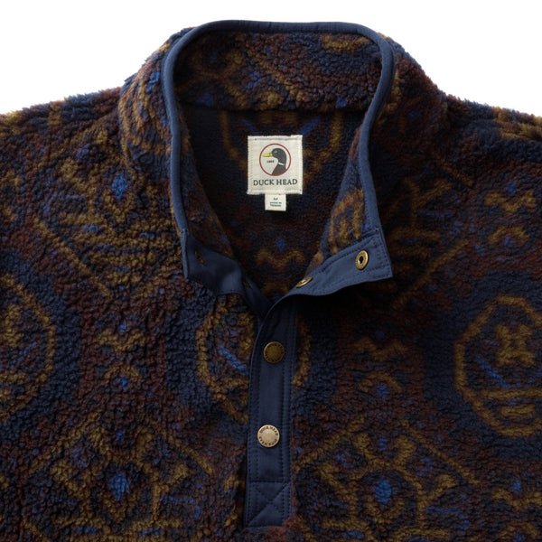 Pineview Fleece 1/4 Snap Pullover by Duck Head in a blue, brown, and orange patterned print with a navy blue placket.