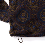 Close-up of a Pineview Fleece 1/4 Snap Pullover by Duck Head, featuring a dark blue and brown geometric pattern and a drawstring hem for lightweight warmth.