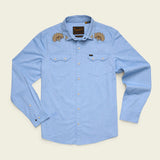 Howler Brothers Crosscut Deluxe Longsleeve in light blue, reminiscent of a faded blue oxford, features Fanned Flora embroidery on the collar, two chest pockets, and classic pearl snap buttons.