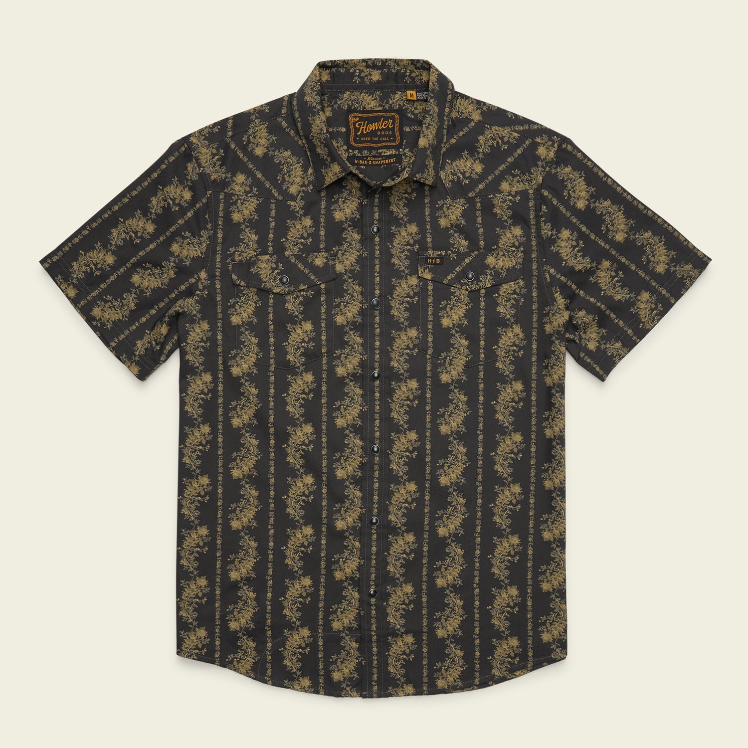 Short-sleeved button-up Howler Brothers Grampa’s Curtains shirt with a dark base and light-colored floral stripe pattern, featuring pearl snaps, two chest pockets, and a pointed collar—a stylish nod to Howler Brothers’ technical utility shirt designs.