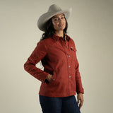 A woman wearing the Sendero Provisions Co. Women’s Rancho Waxed Jacket stands against a plain beige background.