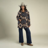 A person wearing a grey cowboy hat, a brown and blue Santa Fe Jacket by Sendero Provisions Co., dark wash wide-leg jeans, and brown boots.