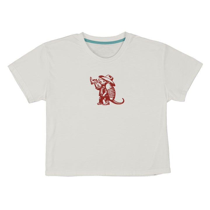 The Armadillo Boxy Tee by Sendero Provisions Co. is a white, short-sleeve T-shirt made from ultra-soft organic cotton, featuring a small red graphic of an armadillo in a hat playing a trumpet centered on the chest.