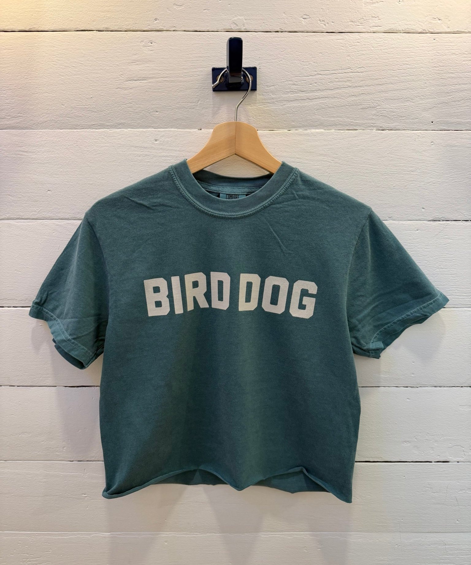 Emerald Bird Dog Honor Crop Ballad of the Bird Dog T-shirt with the text “BIRD DOG” printed in white across the chest.