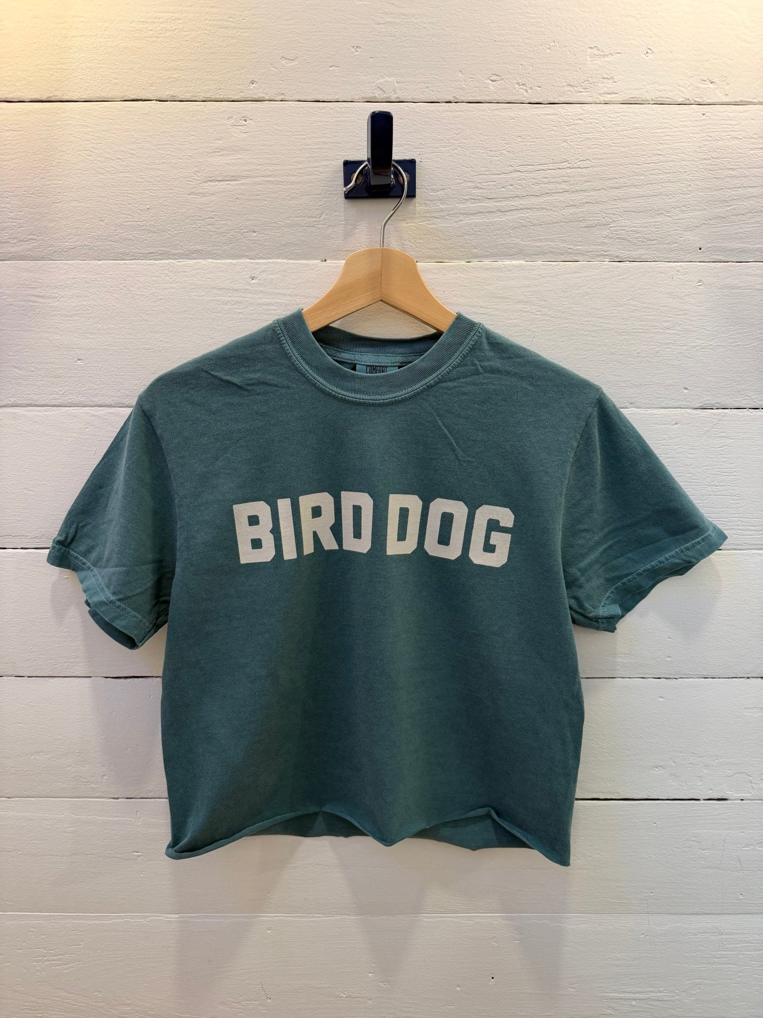 Emerald Bird Dog Honor Crop Ballad of the Bird Dog T-shirt with the text “BIRD DOG” printed in white across the chest.