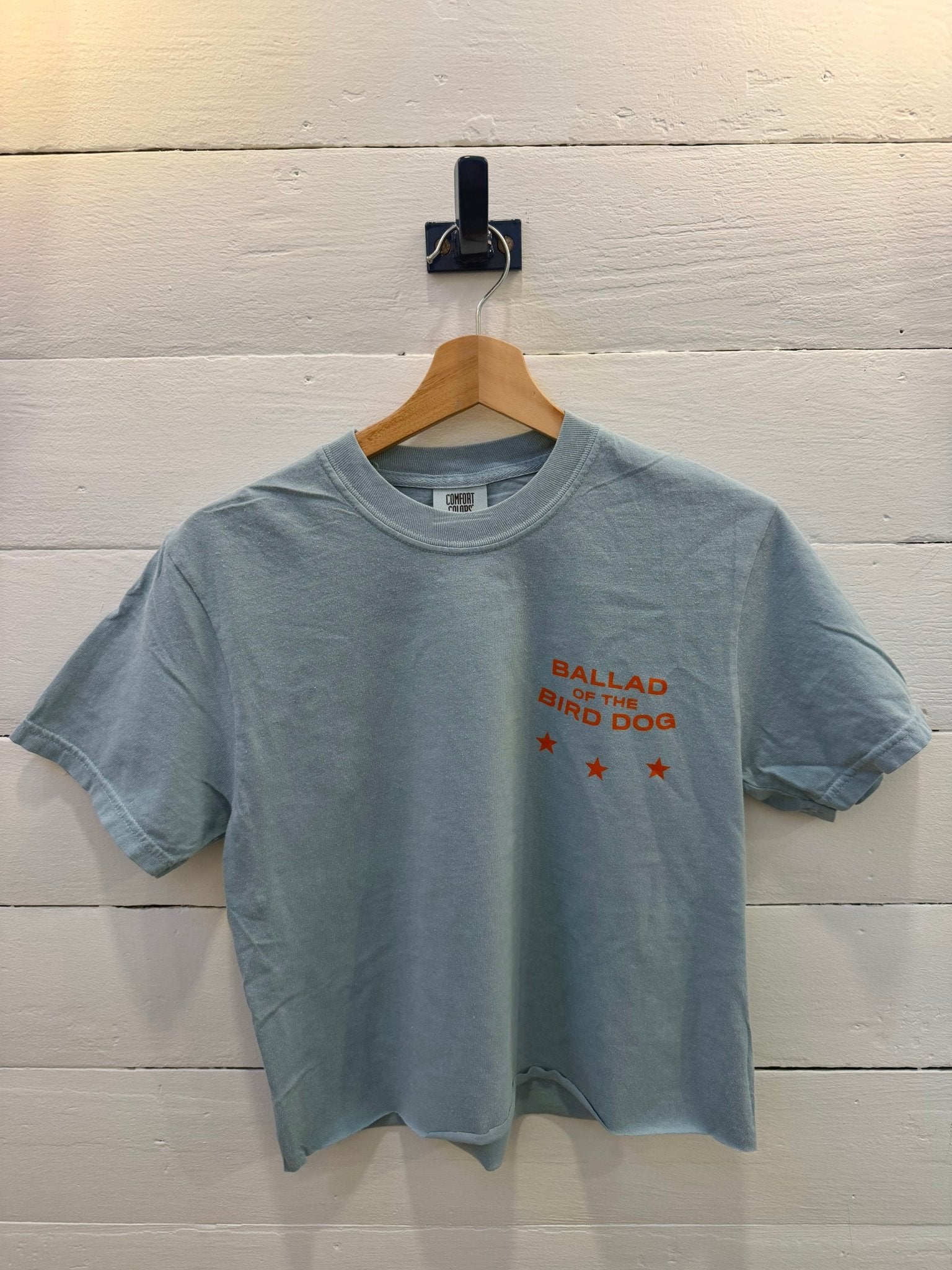 Small Town Revival Crop Ballad of the Bird Dog yankey blue cropped t-shirt with “Ballad of the Bird Dog” and three orange stars printed on the chest.