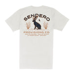 The Jackalope Pocket Tee by Sendero Provisions Co. is a white organic cotton t-shirt featuring a jackalope, plants, moon graphic, “Sendero Provisions Co.” text, and branded details.