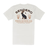 The Jackalope Pocket Tee by Sendero Provisions Co. is a white organic cotton t-shirt featuring a jackalope, plants, moon graphic, “Sendero Provisions Co.” text, and branded details.