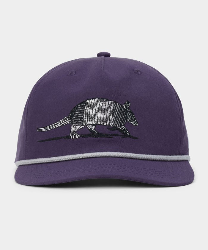 The Armadillo Hat by Duck Camp is a purple 5-panel cap with a stylish grey rope detail above the brim, featuring an embroidered armadillo on the front and an adjustable snapback for a comfortable fit.