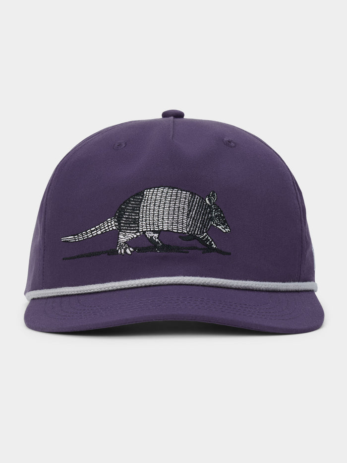 The Armadillo Hat by Duck Camp is a purple 5-panel cap with a stylish grey rope detail above the brim, featuring an embroidered armadillo on the front and an adjustable snapback for a comfortable fit.