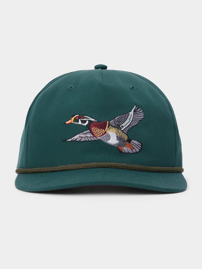 Duck Camp Wood Duck Hat by Duck Camp, a green snapback featuring an embroidered flying duck on the front and a dark green band above the brim. Made with a durable polyester shell and adjustable fit, shown against a plain background.