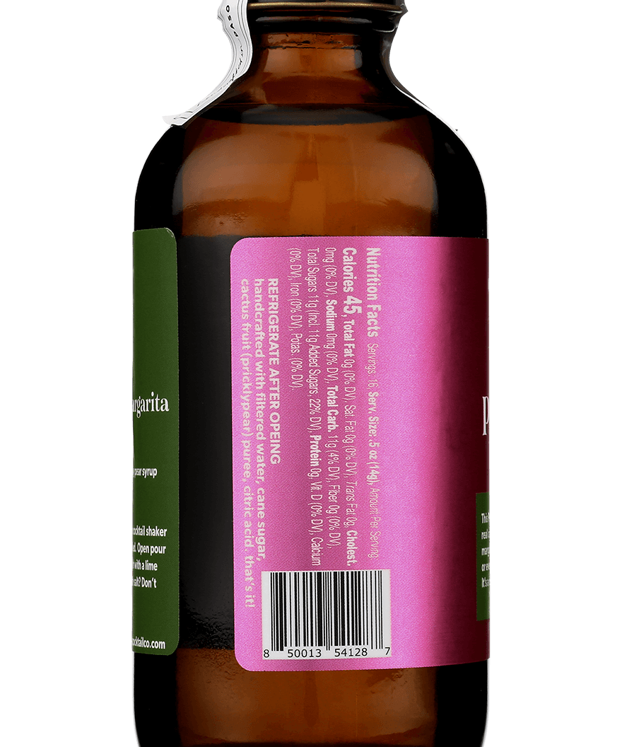 A brown glass bottle with a torn white seal and a magenta label, listing Prickly Pear Syrup ingredients, barcode, and the Yes Cocktail Co. brand name, viewed from the back.