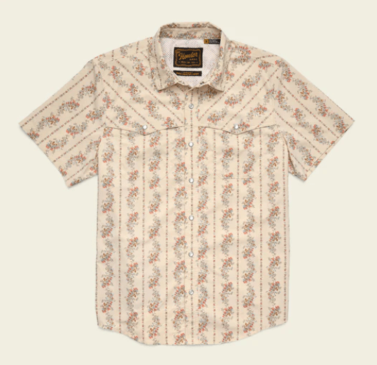 The Howler Brothers Grampa's Curtains is a beige short-sleeve button-up with floral and stripe patterns, two chest pockets, vented rear yoke for breathability, and an inside collar label.
