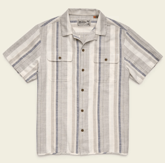 The Howler Brothers Shores Club Shirt features a vintage textured weave, camp collar, short sleeves, vertical beige, white, and gray stripes, two chest pockets, and brown buttons—ideal for spring 2026. Laid flat on a light background.