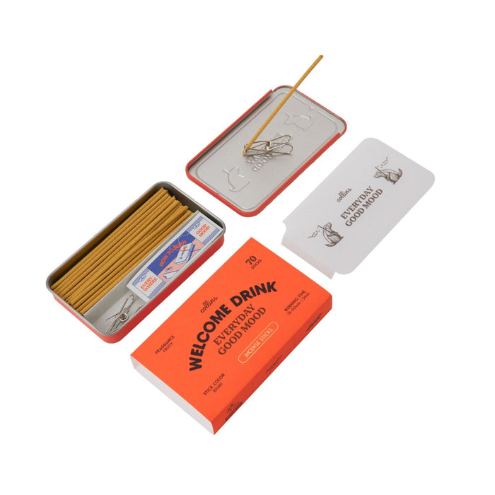 Rectangular metal tin containing Collins Welcome Drink Incense Sticks, crafted from natural ingredients, along with a small holder and an orange box labeled “Welcome Drink Goodwood”—all by Collins. A white card is included. Enjoy a delightful fruity aroma with every use.