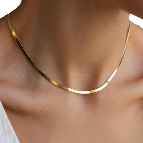 A person wears the Zoe Gold Snake Chain Necklace by Peter and June around their neck, paired with a white top visible at the shoulder.