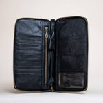 The Stash Passport Wallet | Luxe Black Croc is shown open against a plain background, revealing card slots, a secure zippered pocket, spacious compartments, and a clear ID window—ideal for keeping your essentials organized as a leather travel wallet or passport wallet on the go.