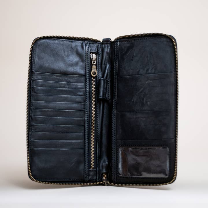 The Stash Passport Wallet | Luxe Black Croc is shown open against a plain background, revealing card slots, a secure zippered pocket, spacious compartments, and a clear ID window—ideal for keeping your essentials organized as a leather travel wallet or passport wallet on the go.