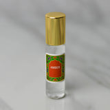 Amber Perfume Oil by Nemat is a small glass bottle with a gold cap and a decorative "Amber" label, resting on light gray marble. This subtle scent is perfect as your personal fragrance.