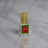 A small Nemat Amber Perfume Oil bottle with a gold cap and red label rests on marble, ready to reveal its subtle amber fragrance as your new signature scent.