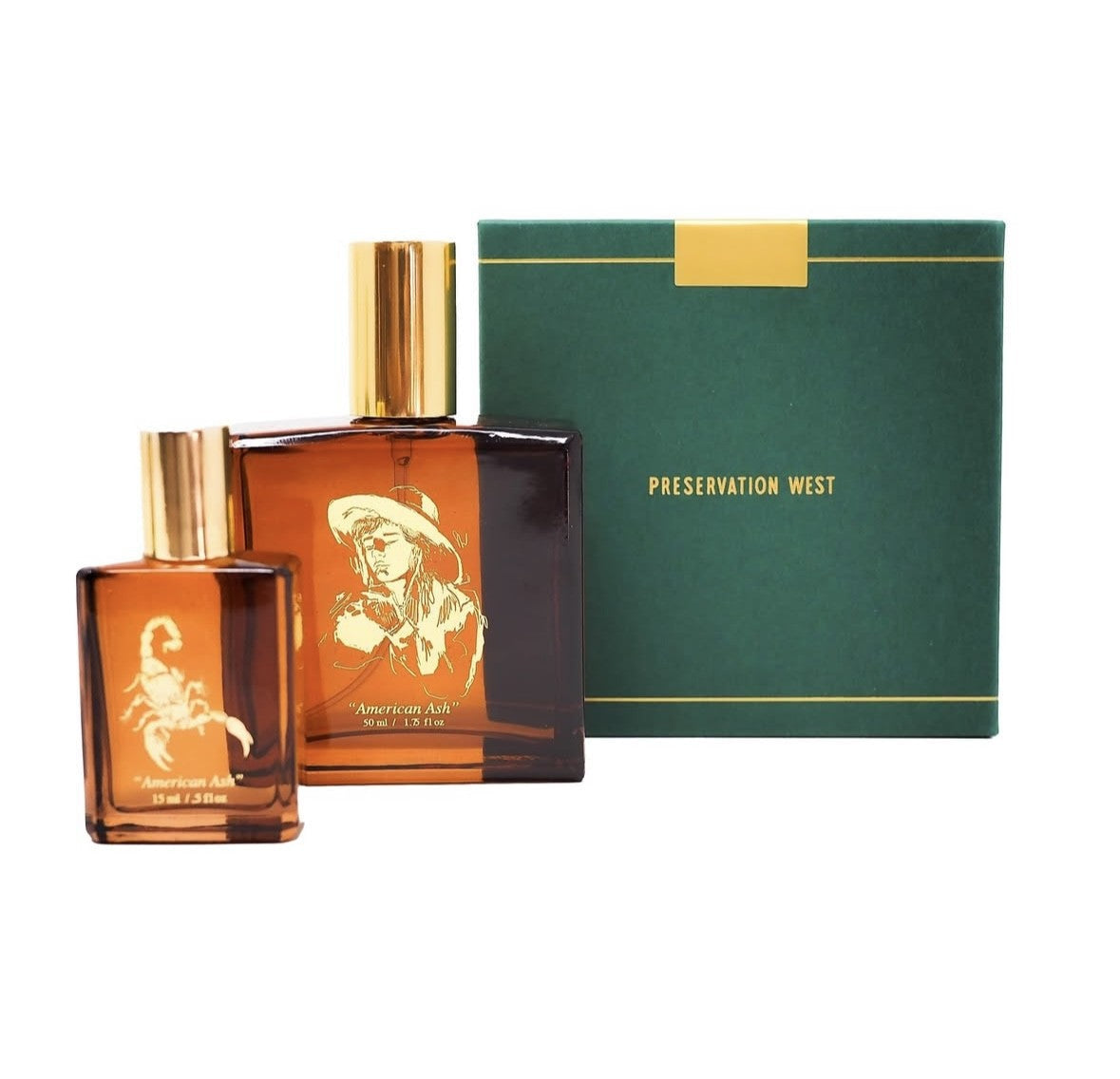 Two amber glass perfume bottles with gold caps sit before a green "Preservation West" box. American Ash by Preservation West, featuring a scorpion and a cowboy, evokes mysterious notes of Patchouli and Oud.