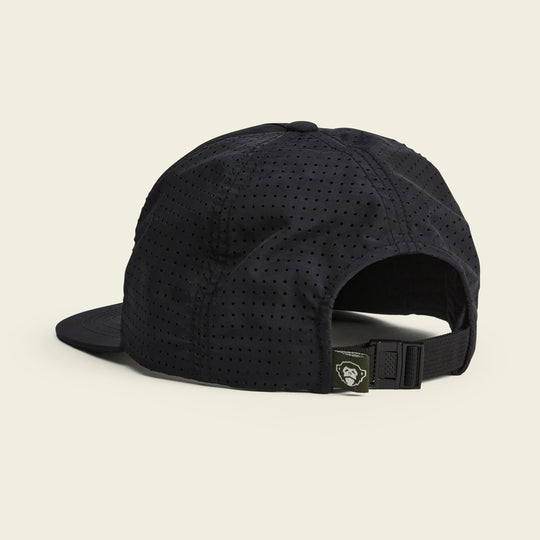 The Howler Brothers Aperture Tech Strapback is a black, perforated cap shown from the back with an adjustable strap and a logo tag—an ideal breathable hat for outdoor adventures.