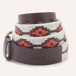 The ATX Dark by Zilker Belts is a hand-stitched Argentine leather belt featuring white and orange geometric patterns and "ZILKER" embossed near the buckle.