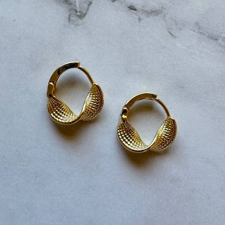 The Azalea Gold Filled Huggie Hoop Earrings by Jessica Matrasko Jewelry feature textured, shell-inspired detailing—stylish, hypoallergenic hoops perfect for daily wear.