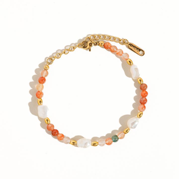 Jolin Bohemian Stone and Bead Bracelet by Flanerie by MAIQ featuring orange stone beads, natural pearls, 18K gold-plated spacers, a gold-toned chain, and a lobster clasp.