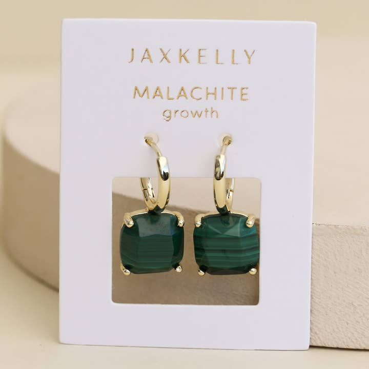 A pair of JaxKelly Gemstone Mini Drop earrings featuring square green malachite stones and 18K gold plating, beautifully presented on a white card labeled “MALACHITE growth.”.