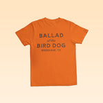 Orange Upland Shirt with a comfortable everyday fit, featuring “BALLAD of the BIRD DOG BRENHAM, TX” printed on the back.