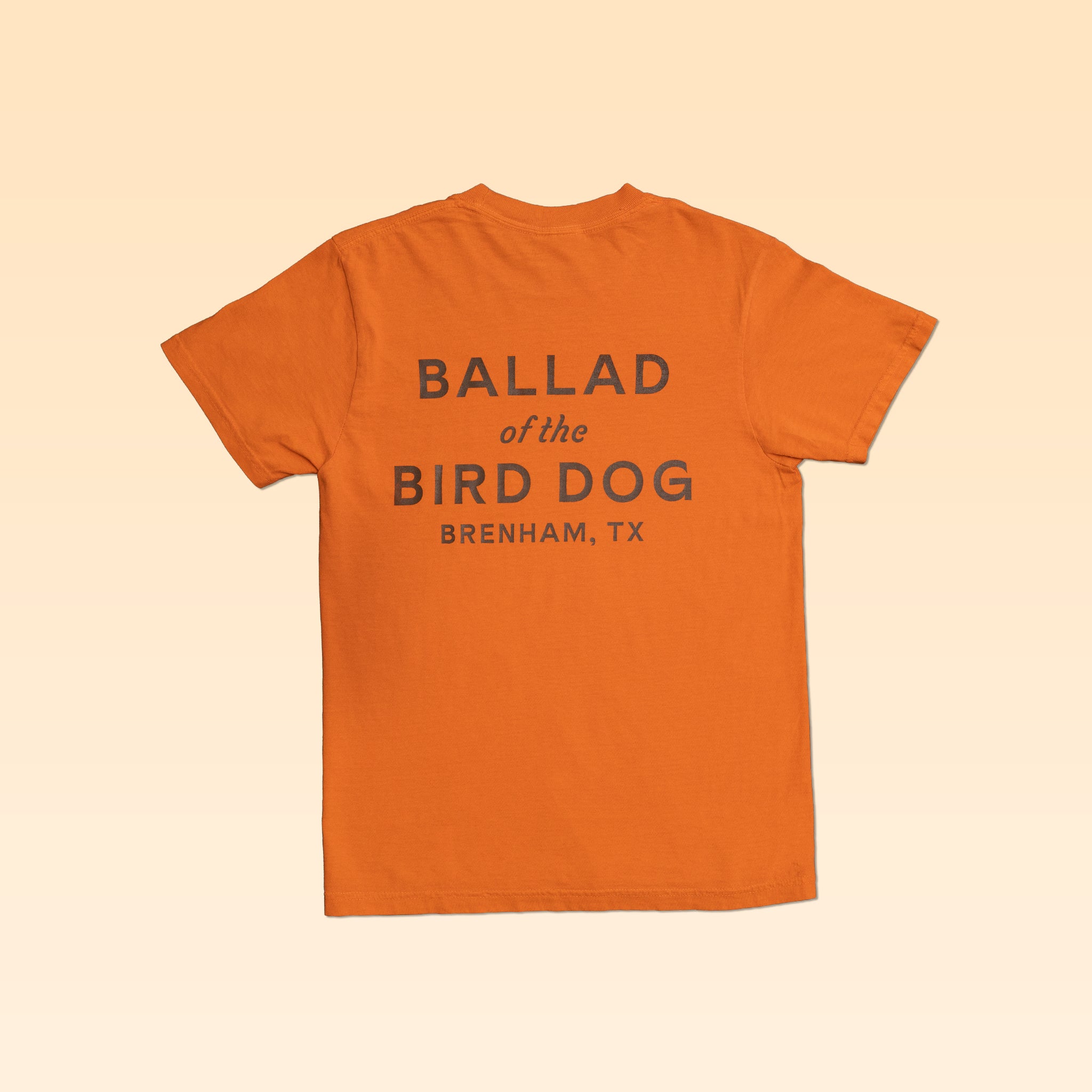 Orange Upland Shirt with a comfortable everyday fit, featuring “BALLAD of the BIRD DOG BRENHAM, TX” printed on the back.