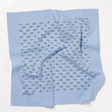 The Jenni Earle "Fuck All Y'All" Bandana is an ethically made, light blue cotton bandana with a pattern of dark blue lines and dots and a signature in one corner, shown laid flat on a white surface.