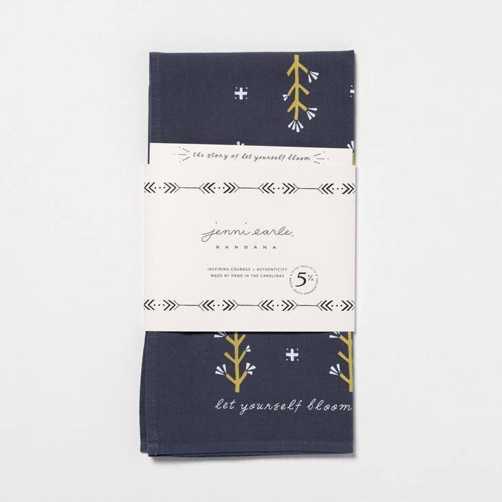 The Jenni Earle "Let Yourself Bloom" Bandana is hand-dyed in navy blue with a floral design and message, wrapped in branded paper and made from sustainable cotton for feel-good style.