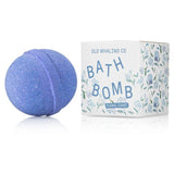A purple floral bath bomb rests beside a floral-decorated box labeled “Bath Bomb | Floral Coast | Old Whaling Co.,” from Old Whaling Co., featuring a relaxing hydrangea scent.
