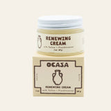 A small glass jar of OCASA Renewing Frankincense-Infused Tallow Cream resting on its matching square cardboard box.