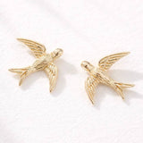 Introducing the Mesa Blue Swallow Stud Earrings—18K gold plated and delicately crafted in the shape of flying birds. These lightweight earrings from Mesa Blue are elegantly displayed on a white surface, adding a stylish touch to any look.