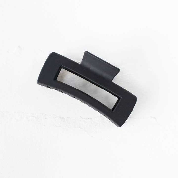 The Beyond the Border Hair Clip by Tiepology is a comfortable black accessory featuring a rectangular cut-out center, displayed on a white surface.