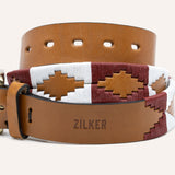 The Big Bend by Zilker Belts is a brown Argentine leather belt with "ZILKER" engraved and red, white, and beige hand-stitched geometric embroidery.