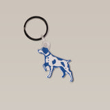 The Bird Dog Keychain by Ballad of the Bird Dog features a blue and white dog silhouette with spots, crafted from silicone with a metal key ring—perfect for outdoorsmen.