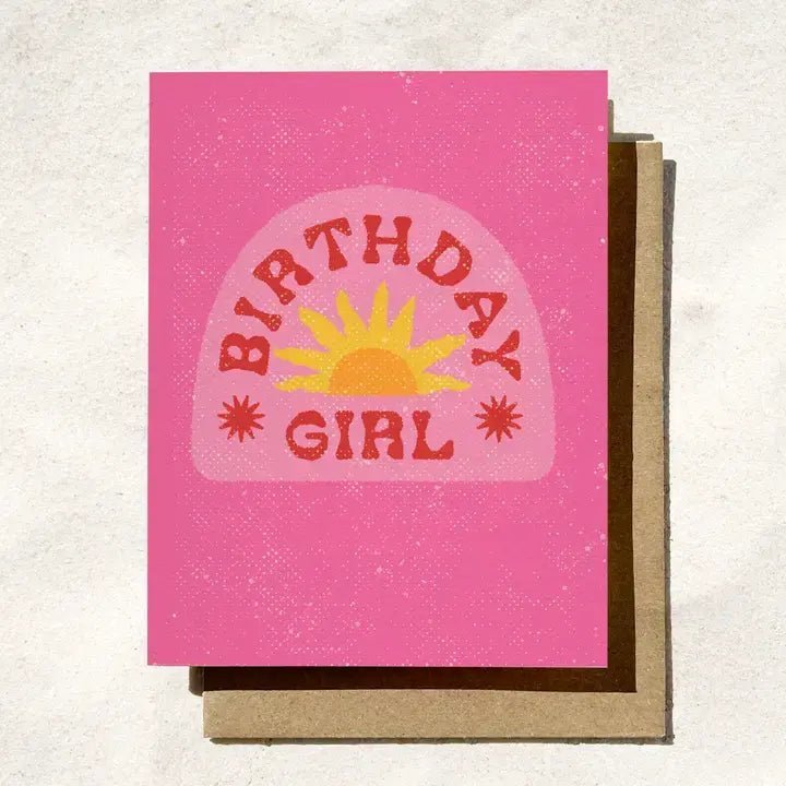 The "Birthday Girl | Retro Pink Sun" card by Daydream Prints features a bold sun illustration and vibrant lettering, presented on a brown envelope.