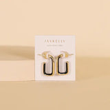 JaxKelly Black Enamel Large Rectangle Gold Hoop Earrings, designed to be hypoallergenic, are displayed on a white JaxKelly card against a beige background.