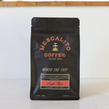 A black bag of Mescalito Coffee’s "High Flyer" blend whole coffee beans offers a medium roast crafted in Brenham, with specialty beans from Peru, El Salvador, and Ethiopia and notes of strawberry, honey, and basil.