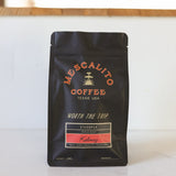 A black bag of Mescalito Coffee’s Blend Whole Coffee Beans | Kalimaz features a medium roast from Ethiopia with bold dark chocolate and raspberry notes, labeled "Worth the Trip.