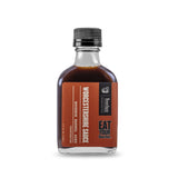 A clear glass bottle with a black cap, labeled "Bourbon Barrel Aged Worcestershire" by Bourbon Barrel Foods. This all-natural, vegetarian sauce features the “Eat Your Bourbon” branding on the label.