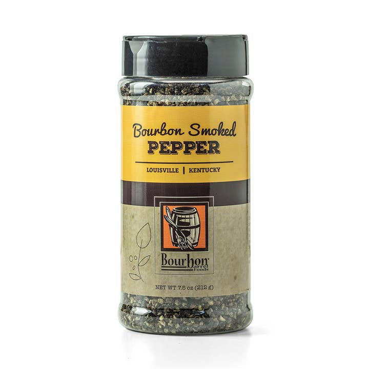 A 7.5 oz (212 g) plastic container of Bourbon Smoked Pepper by Bourbon Barrel Foods, made with Malabar pepper, has a yellow and brown label highlighting its Louisville, Kentucky origin.