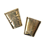 The Brass Bandana Slide by Jenni Earle features two small, gold-toned metal cups with embossed horseshoe and western designs—ideal as unique bandana slides or brass bolo accents.